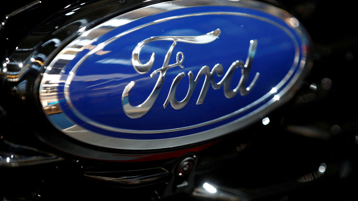 Close-up of the Ford blue oval logo reflecting light on a polished vehicle grille.
