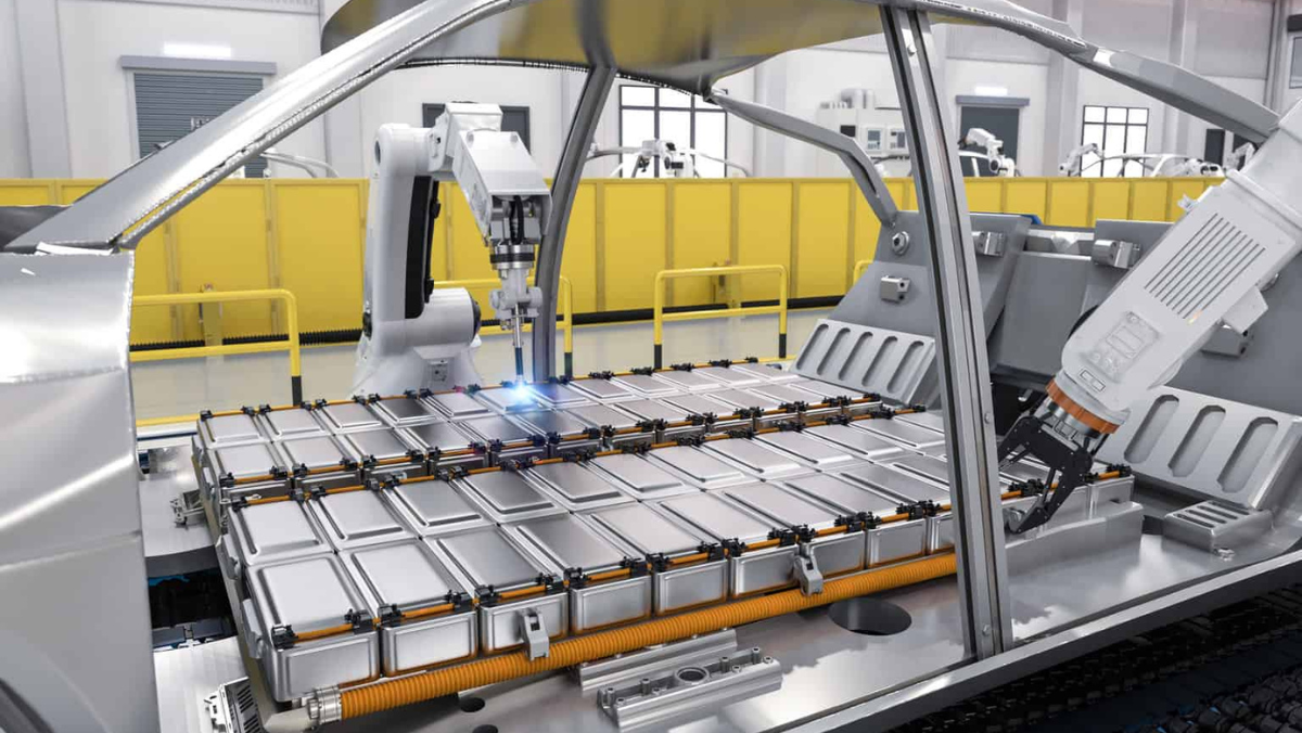 Robotic assembly system working on EV battery modules inside an automated manufacturing line.