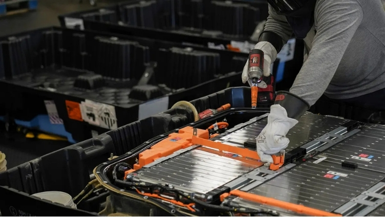 Technician disassembling electric vehicle battery pack for recycling